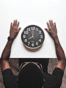 High angle view of a man with an apple watch observing a clock on a white table. Balancing Work and Relationships – How distractions during partner time create emotional distance