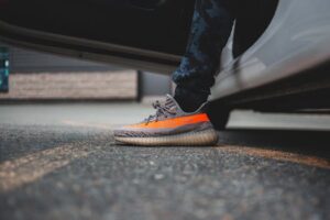 Close-up of stylish sneakers stepping out of a vehicle, highlighting urban fashion.