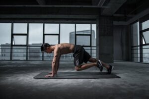 Fit man doing mountain climbers exercise inside a modern gym. What Is Nightfall and Why It Happens Frequently: Causes, Effects, and Solutions – Meditation helps control nightfall naturally