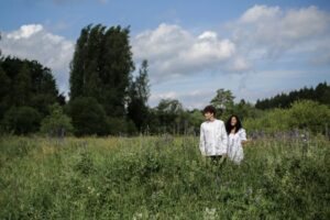 A young couple enjoying a walk through a lush, summer meadow with lupines and greenery.Best Date Ideas for Couples: How Going on Outings Builds a Healthy Relationship – couple enjoying a romantic date outdoors