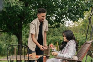 A young man and woman enjoy sharing apples in a lush garden setting.Best Date Ideas for Couples: How Going on Outings Builds a Healthy Relationship – couple enjoying a romantic date outdoors